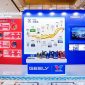 A display booth featuring Valvoline GEELY collaboration, showcasing co-developed lubricants and a timeline of their partnership, with product bottles arranged on a central table.