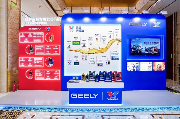 A display booth featuring Valvoline GEELY collaboration, showcasing co-developed lubricants and a timeline of their partnership, with product bottles arranged on a central table.